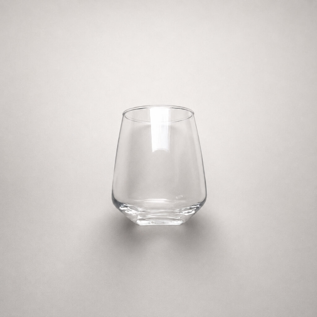 Elegancka szklanka tumbler o nowoczesnej, wyrazistej linii projektowej, wyeksponowana w minimalistycznym wnętrzu jadalni jako luksusowy detal wchodzący w skład serii Sunrise & Luna Quattro Love.
